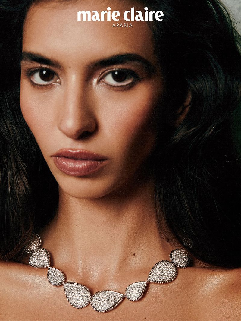 Close-up shot of a brunette woman with fair skin wearing a silver necklace, with the "Marie Claire Arabia" magazine logo visible.