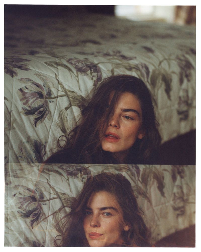 Model Merlijne Schorren pictured indoors against a floral patterned bedspread for Vogue Netherlands Scotland Yarn editorial