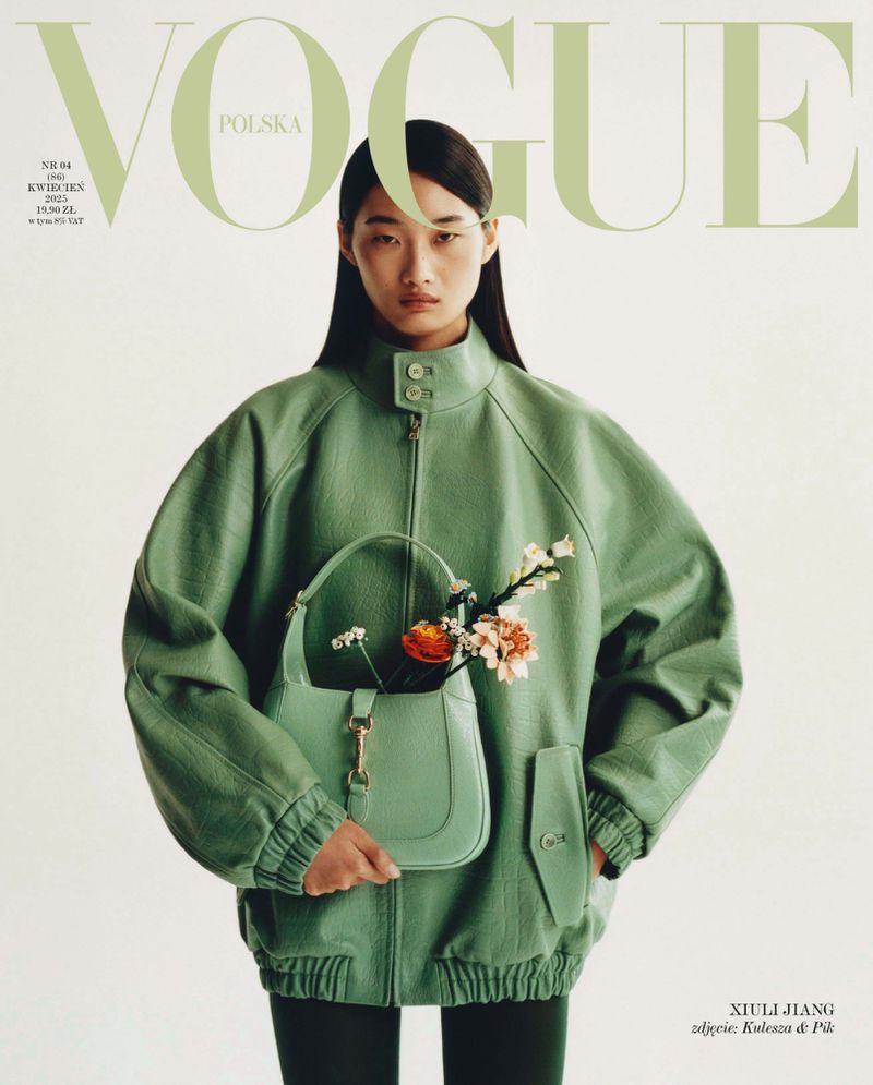 Vogue Polska cover featuring an Asian female model in a light-green outfit, holding a handbag with flowers against a white background.