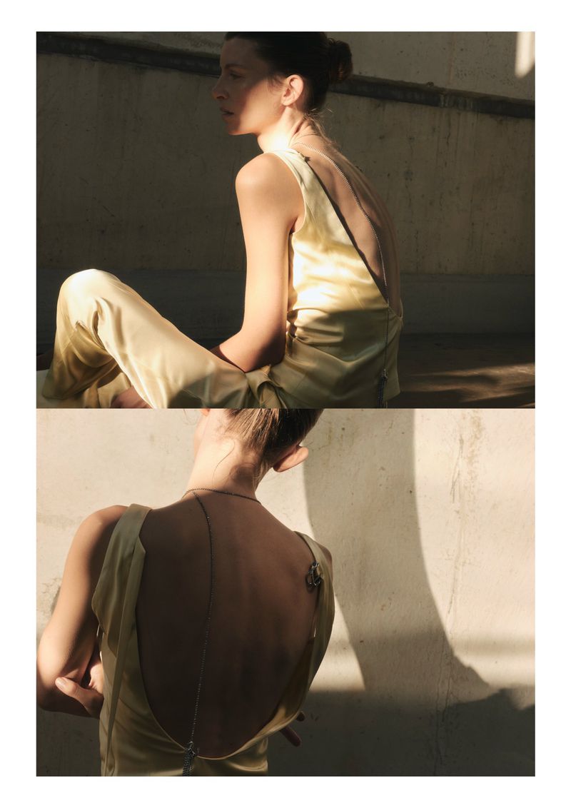 A woman in a light yellow sleeveless top and pants sits on a concrete surface in natural sunlight, presented in a split-level perspective.