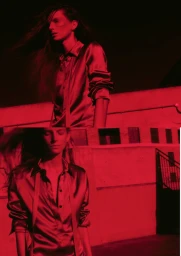 Model Luca Gajdus in a red satin shirt against a wall under intense red lighting for D Repubblica