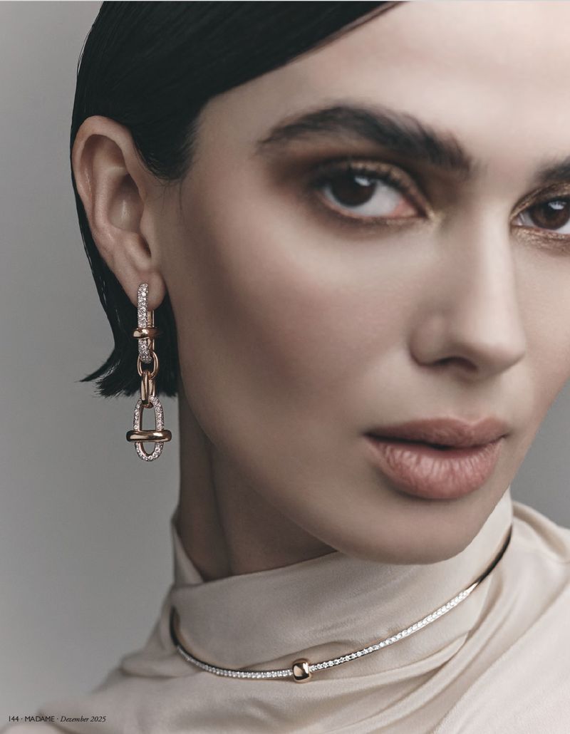 Close-up of a woman wearing earrings and a necklace with diamonds in a studio setting, showcasing beauty and jewelry product photography.
