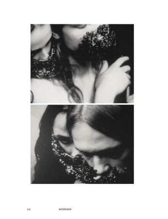 Black and white image showcases two fashionable women wearing beaded necklaces covering their faces in a studio setting. Editorial fashion.