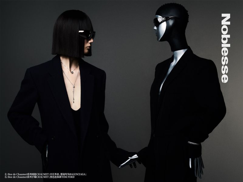 Fashion editorial image featuring a human model and mannequin in black blazers and sunglasses against a grey background, Nobless magazine.