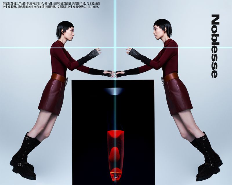 Two adult women pose indoors wearing a maroon top and matching mini skirt, with black boots and gloves, next to a lava lamp.