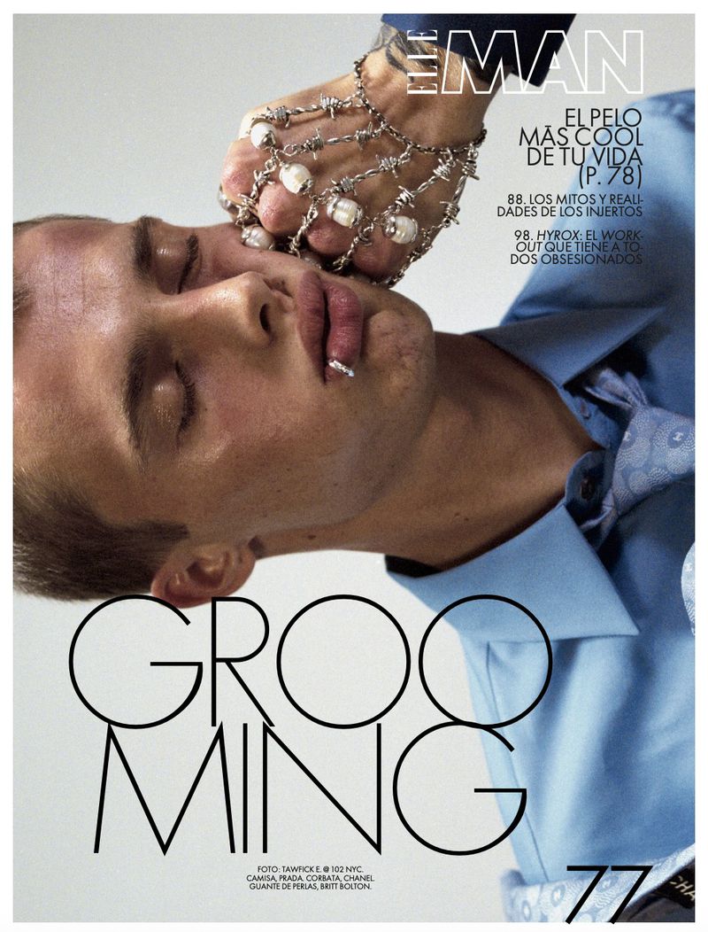 Magazine cover featuring a male model with decorative hand jewelry. The model's eyes are closed in a close-up studio shot.