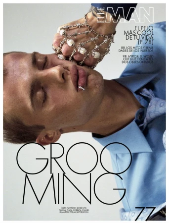Magazine cover featuring a male model with decorative hand jewelry. The model's eyes are closed in a close-up studio shot.