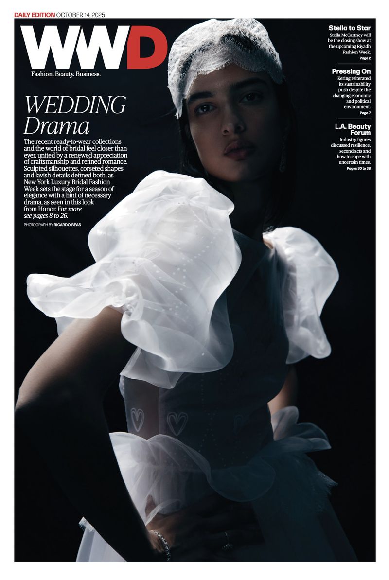 Magazine cover featuring a model wearing a white bridal gown with sheer puffed sleeves and a matching headpiece against a dark backdrop.