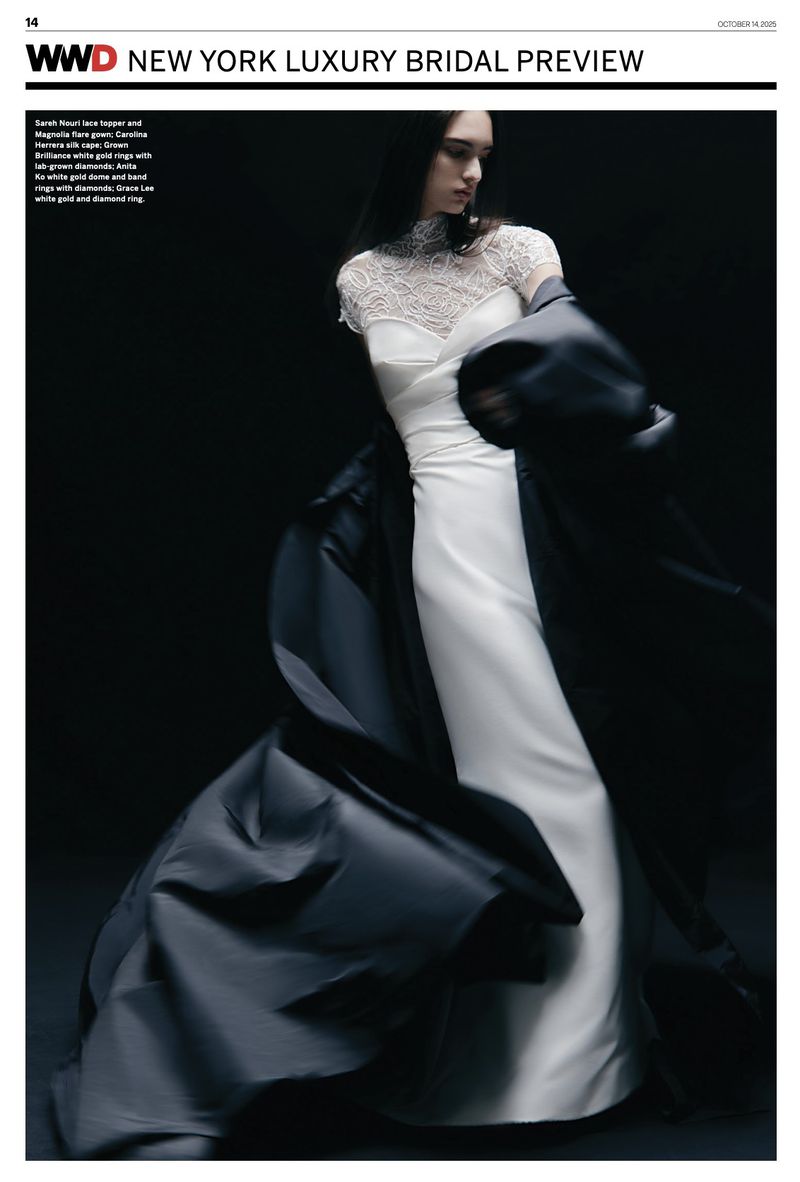 Elegant woman in a white lace and satin bridal gown with a dark coat, captured in a studio setting against a dark backdrop.