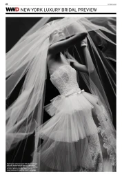 Model in a strapless lace bridal gown and voluminous sheer tulle veil posing in a black and white editorial shoot.