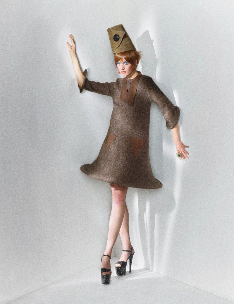 Model Daria Strokous wearing a brown shift dress and tall hat leaning in a corner for W Magazine China