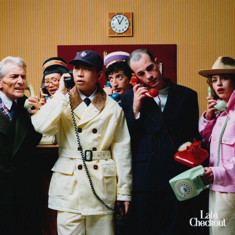 A group of six diverse people talking on vintage rotary telephones in a studio setting with retro design elements and warm lighting.
