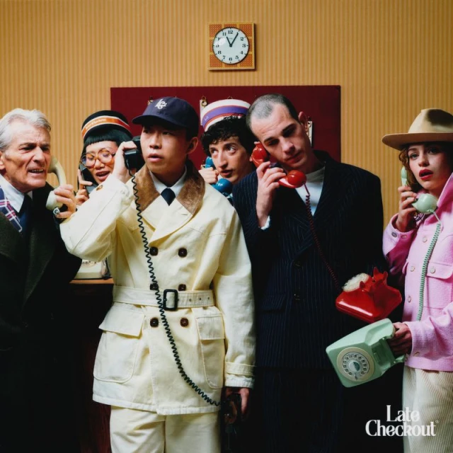 A group of six diverse people talking on vintage rotary telephones in a studio setting with retro design elements and warm lighting.