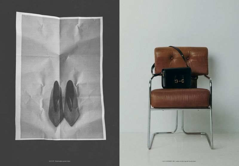 Still life of high-heeled shoes on crumpled paper and purse on chair in bright, minimalist setting, shot in black and white.