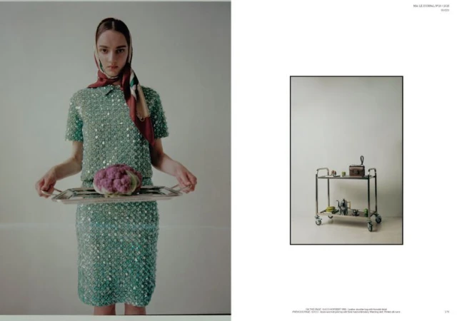 Model wearing a green sequin dress and patterned headscarf holds a silver tray with purple cauliflower beside a rolling cart inset.