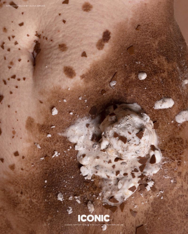 Close-up of a person's torso with uneven skin tone, freckles and an ice cream with chocolate pieces.