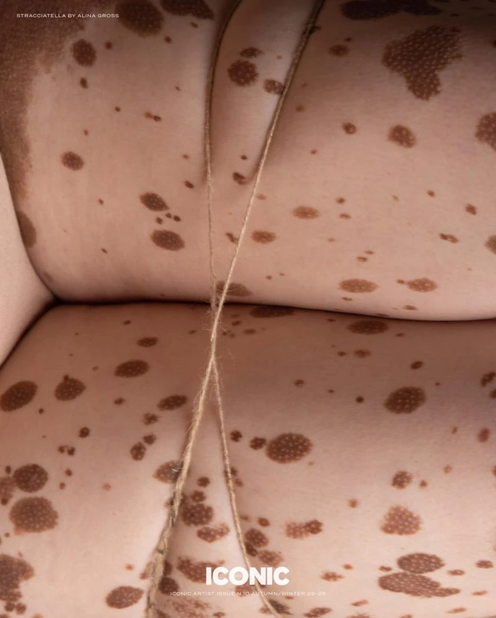 Extreme close-up of spotted skin bound with a thin crisscrossed twine string for Iconic Artist magazine.