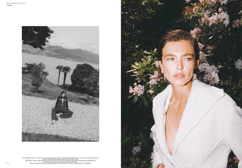 Fashion editorial photo of a stylish young woman in a white jacket posing in a garden with pink flowers, and a black and white landscape.