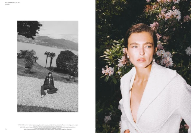 Fashion editorial photo of a stylish young woman in a white jacket posing in a garden with pink flowers, and a black and white landscape.