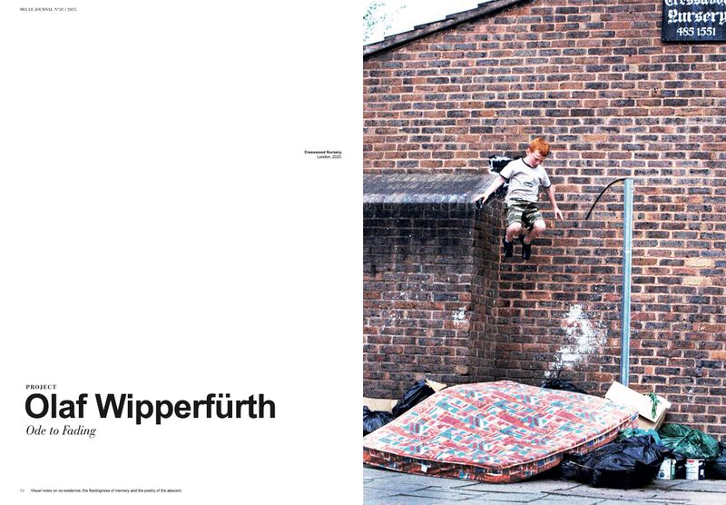 Boy in mid-air leaping off brick wall, with mattress and trash below. Bright red hair and blurred motion accent youthful energy.