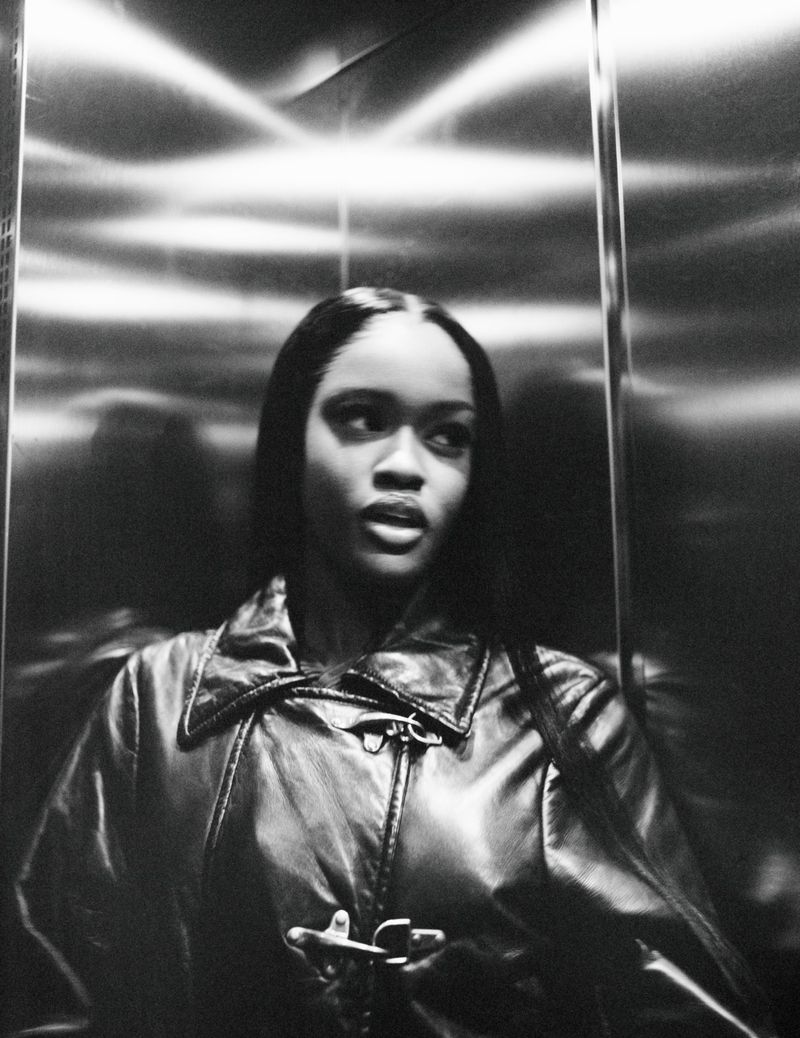 Black-and-white portrait of Chy Cartier wearing a leather jacket inside a metallic elevator for Re-Edition Magazine.