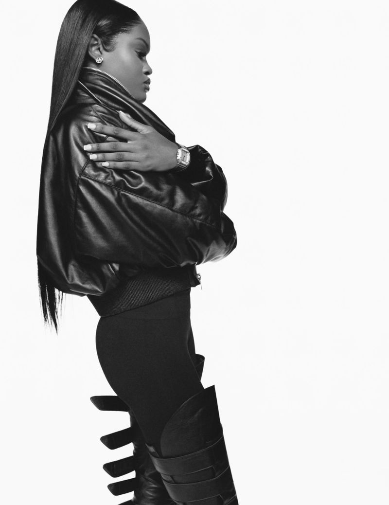 Black woman with long straight hair in a black leather jacket and boots against a white seamless background