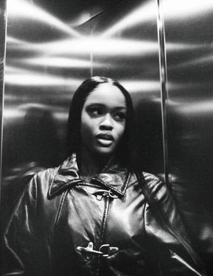 Black-and-white portrait of Chy Cartier wearing a leather jacket inside a metallic elevator for Re-Edition Magazine.