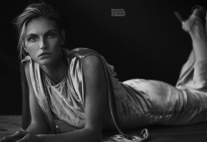 Monochrome portrait of a woman reclining in a satin dress, with a dark backdrop enhancing the elegant and timeless atmosphere of the image.
