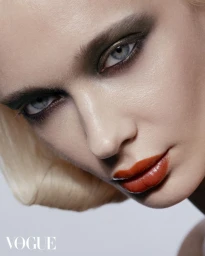 Close-up beauty portrait of model Tat Katysheva with dramatic dark smokey eye makeup and glossy orange lips.