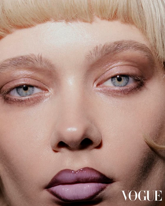 Close-up beauty portrait of a model with blue eyes, blonde hair, and dark lip liner for Vogue Hong Kong.