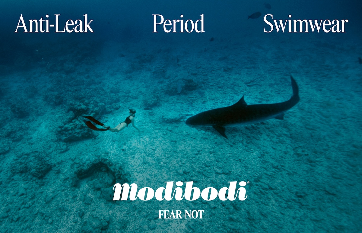 Underwater shot features a woman snorkeling near a shark in the ocean, with the Modibodi brand and text 'Anti-Leak Period Swimwear'.