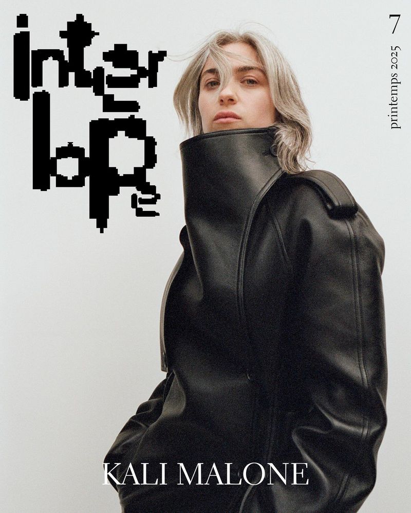 Fashion editorial portrait of an adult woman with gray hair wearing a black leather jacket against a white background, with black text.