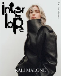 Model wearing a black leather jacket with a high collar against a plain white background for Interlope Magazine.