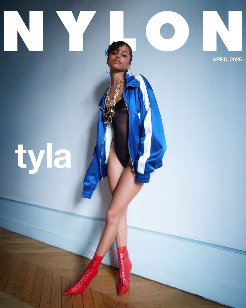 Fashion editorial cover featuring a young woman in a blue jacket, black bodysuit, gold necklace, and red boots leaning against a wall.