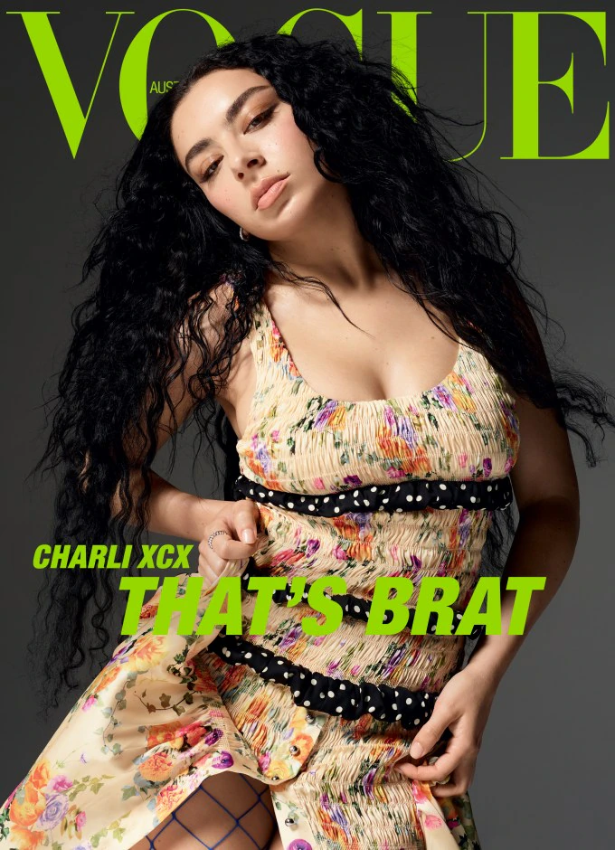 Vogue Australia cover featuring Charli XCX in a floral dress, posing against a grey background. Bright green text overlay.