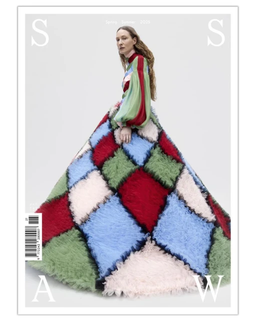 Magazine cover featuring a woman in a colorful patchwork dress. The backdrop is a bright studio. 'S' and 'A' are displayed in text.