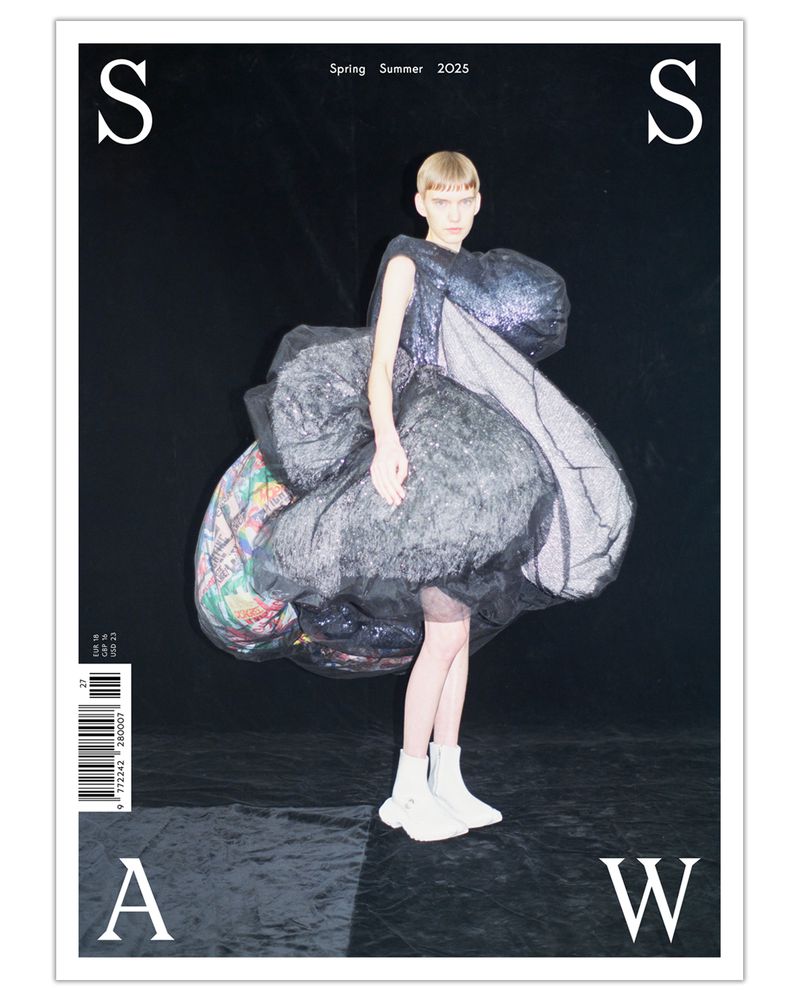 Fashion magazine cover featuring a person in an oversized iridescent dress and white boots, set against a dark backdrop with graphic text.