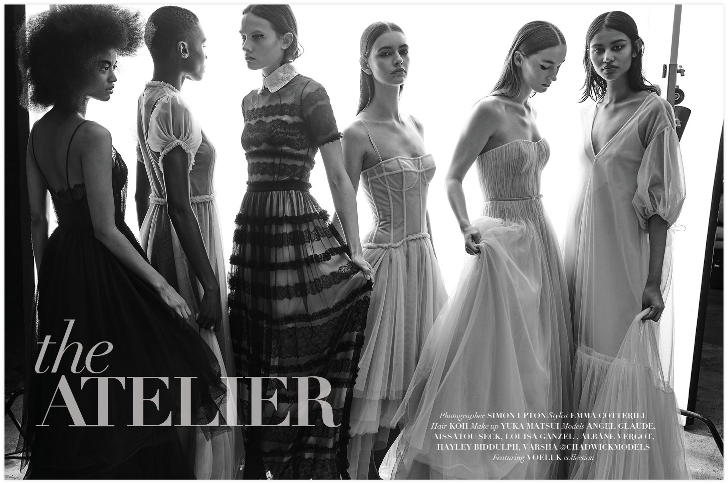 Group of six fashion models in formal tulle dresses posing in a brightly lit studio with soft, diffused lighting, black and white image.