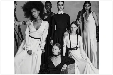 Black and white editorial portrait of six female models wearing elegant contrasting dresses in a studio setting.