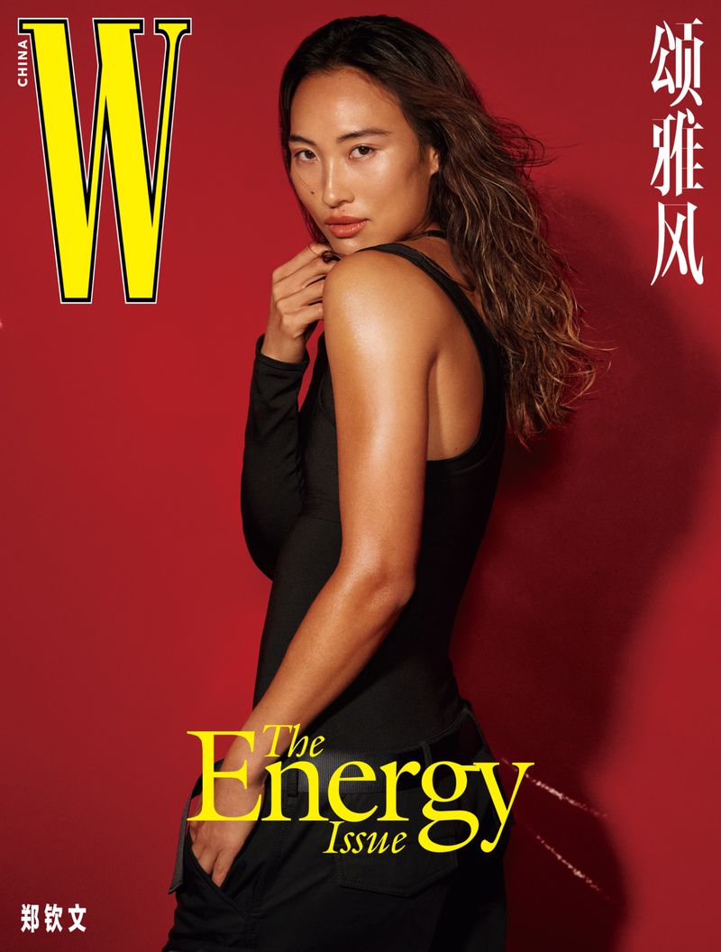 Magazine cover featuring a model with long, wavy hair wearing a black outfit, posed against a vibrant red background with yellow text.