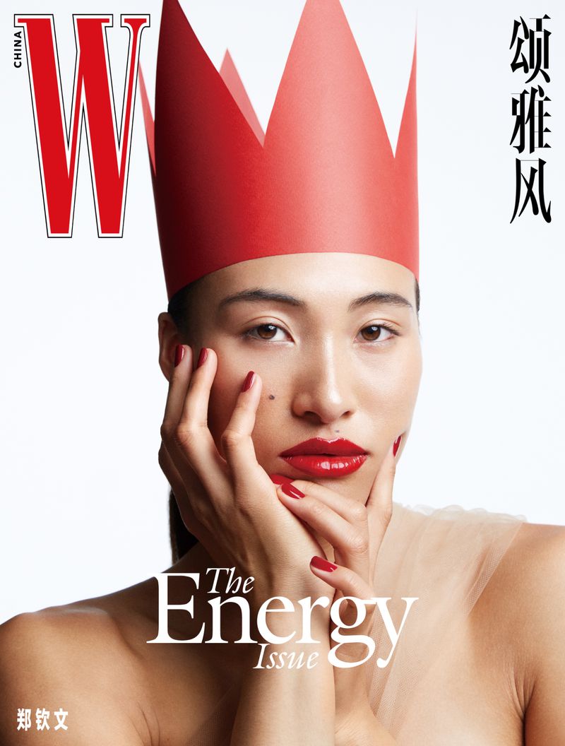 W China magazine cover featuring a woman with pale skin, a red paper crown, red lips and nails, against a plain, light background.