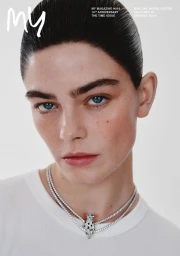Close-up portrait of a model wearing layered diamond necklaces with a panther pendant against a plain white background