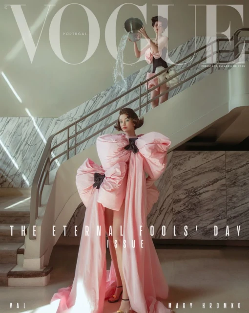 Vogue Portugal magazine cover featuring a model in a pink gown standing on stairs with another woman pouring water in the background.
