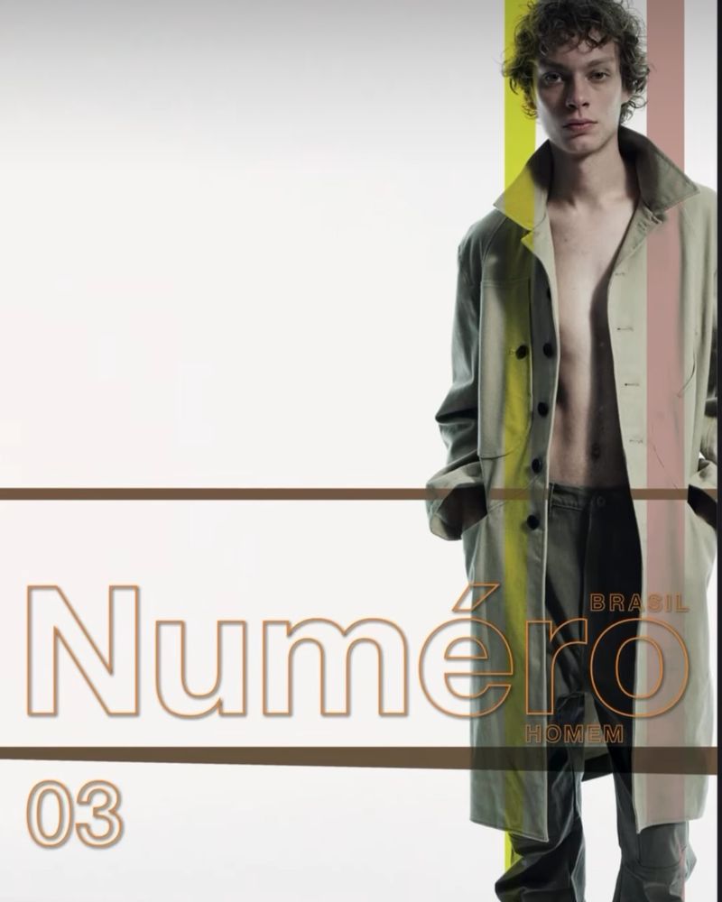 Fashion editorial shot: a young man in an unbuttoned trench coat poses indoors with magazine cover text overlayed, in a bright, modern aesthetic.