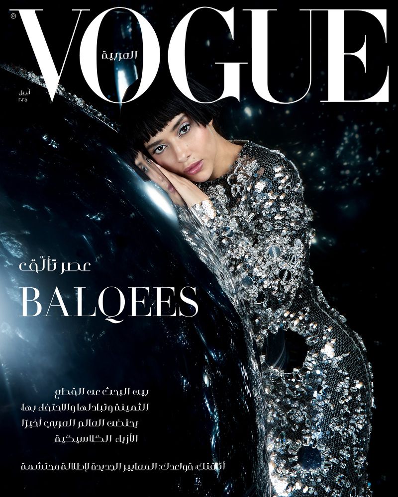 Vogue Arabia magazine cover featuring a woman in an embellished dress leaning against a reflective, glossy surface with a dark background.
