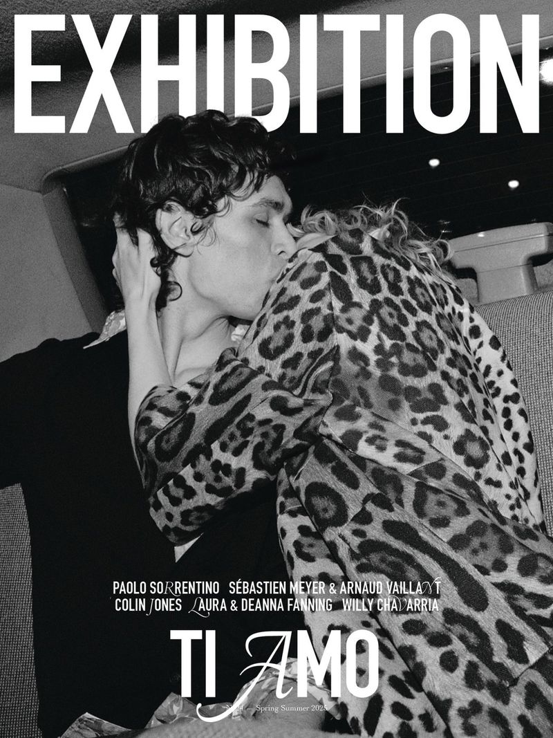 Editorial image of a couple embracing; the man is kissing the woman's cheek. The woman wears a leopard print jacket. 'Exhibition' text at the top.