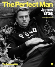 Model James Yates lying among dry autumn leaves wearing a black hoodie in a vertical magazine cover portrait.