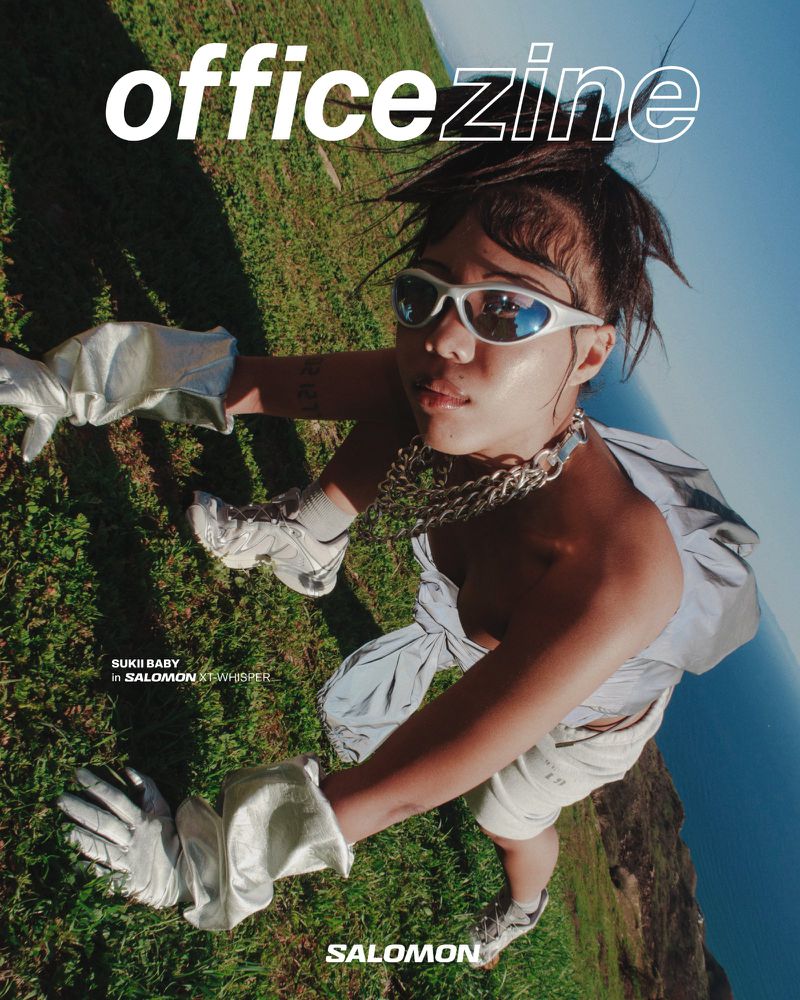 Magazine cover shot at a low angle featuring an adult woman with sunglasses, a chain necklace, gloves, and athletic brand clothing.