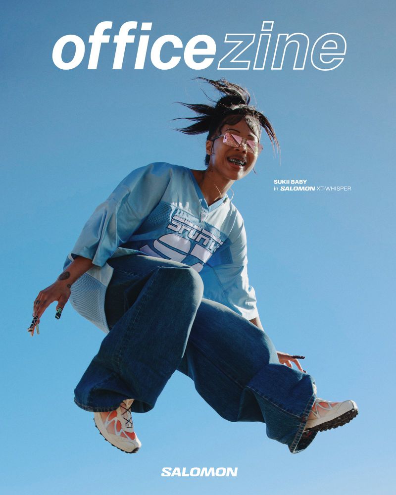 Magazine cover featuring an Asian woman jumping in the air wearing Salomon sneakers against a clear blue sky backdrop, shot from a low angle.