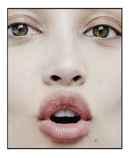 Close-up of a woman's face showing her eyes, nose, and open mouth, emphasizing facial features and textures in a beauty context.